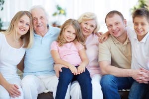 Portrait of senior and young couples with their children looking at camera at home